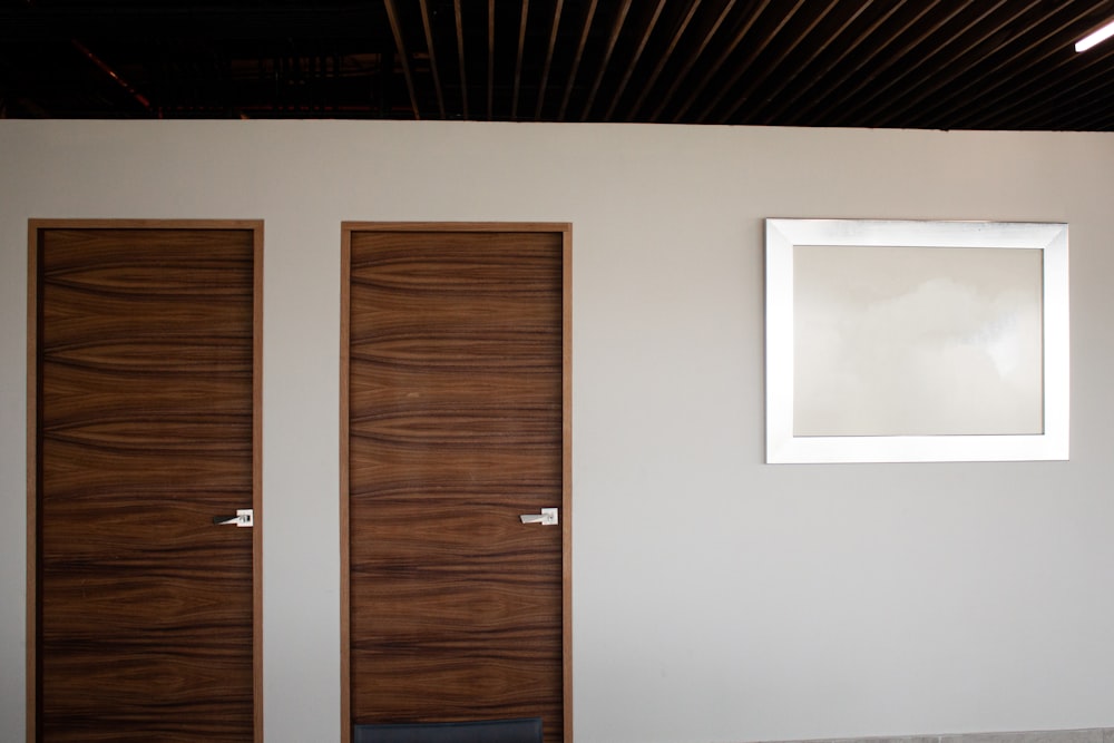 brown wooden door beside white wall