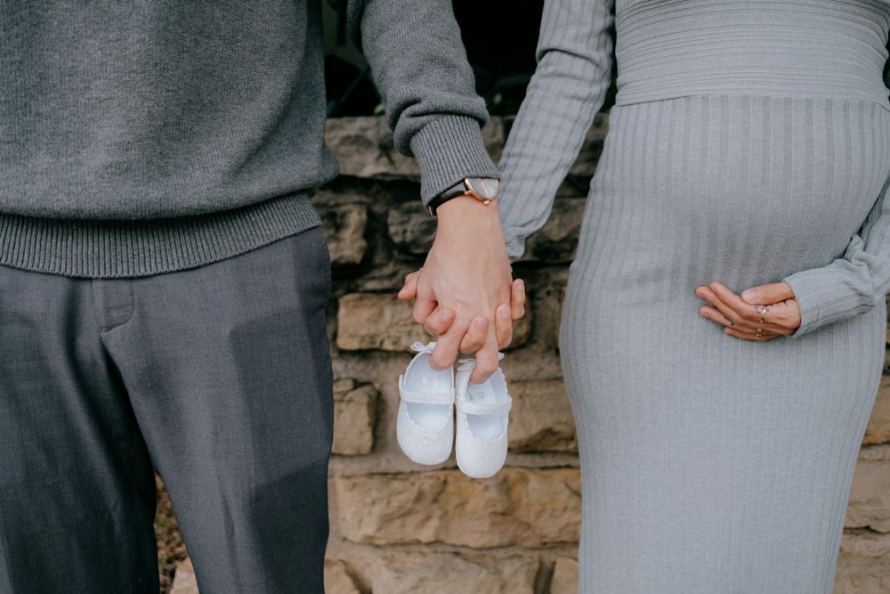 man in gray suit jacket holding woman in gray dress