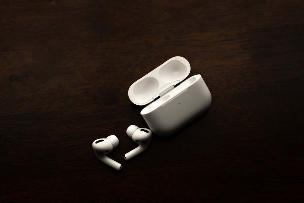 white apple earpods on brown wooden table