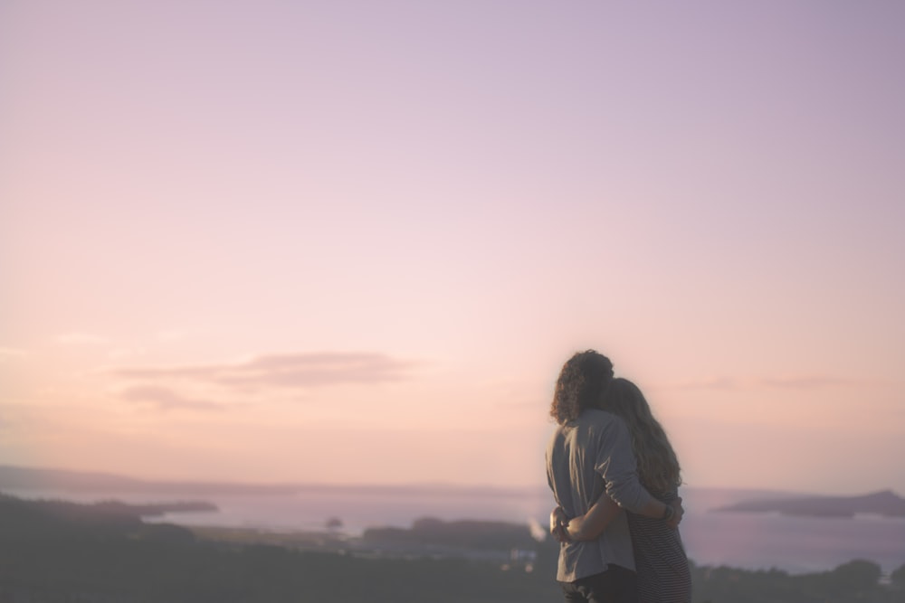 woman in black jacket and black pants standing on top of mountain during daytime