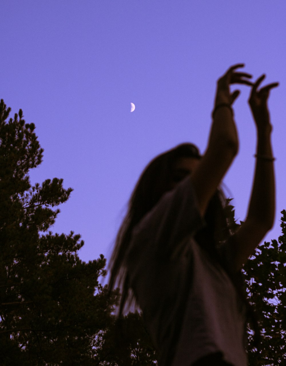 woman in brown shirt raising her hands