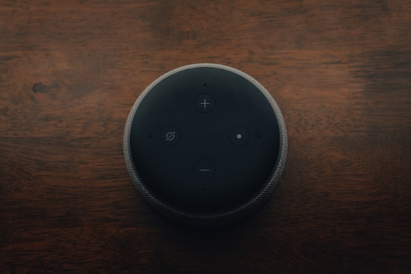 Top view of Amazon Echo device sitting on a wooden table.