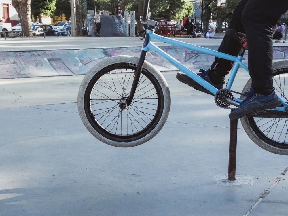 昼間の道路を走る青と黒の自転車