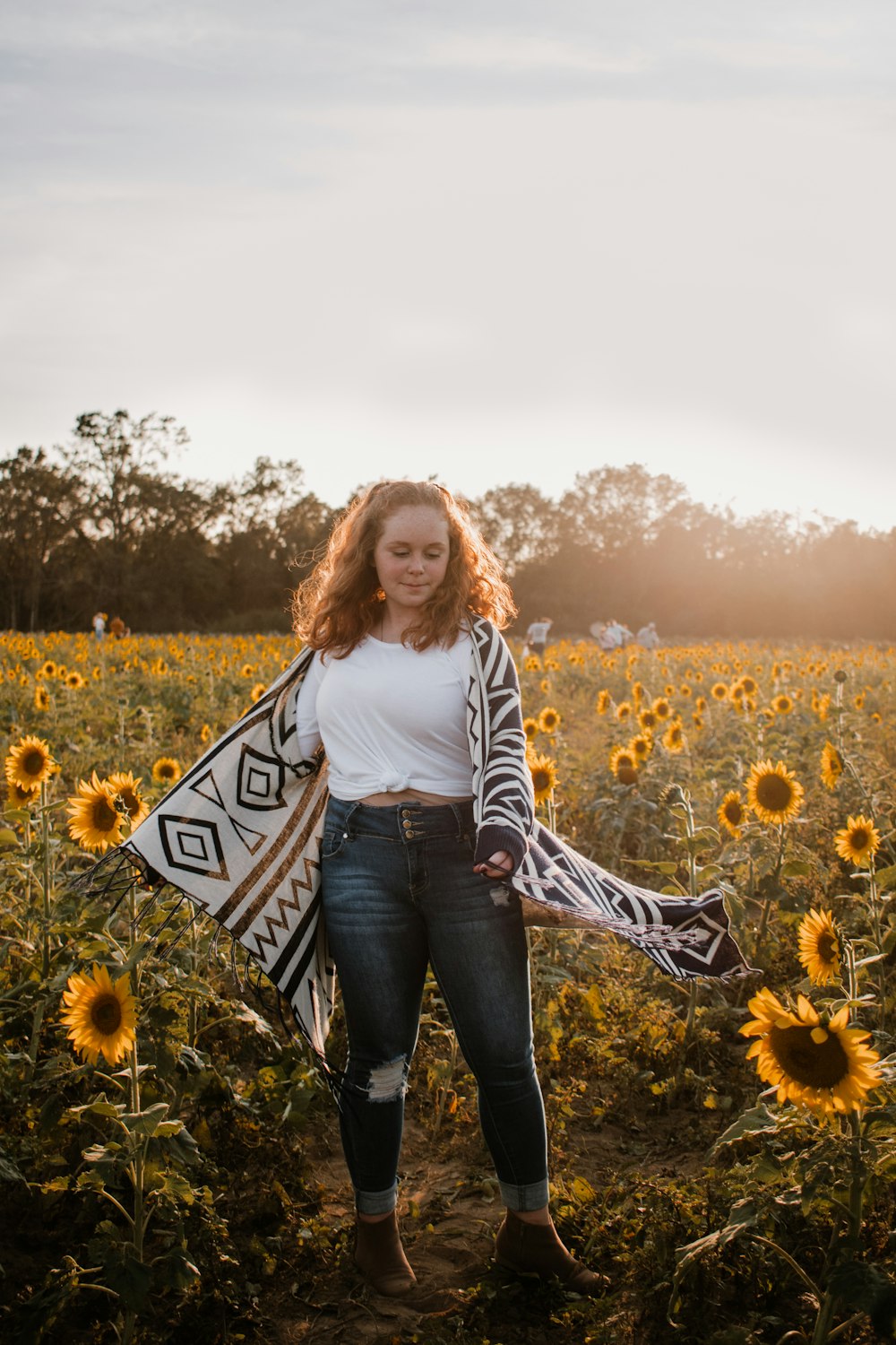 woman in white long sleeve shirt standing on yellow flower field during daytime