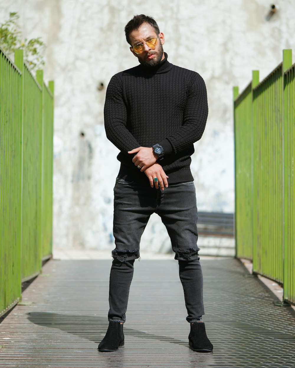 Uomo in maglione nero e pantaloni neri in piedi accanto alla parete verde  durante il giorno foto – Ritratto Immagine gratuita su Unsplash