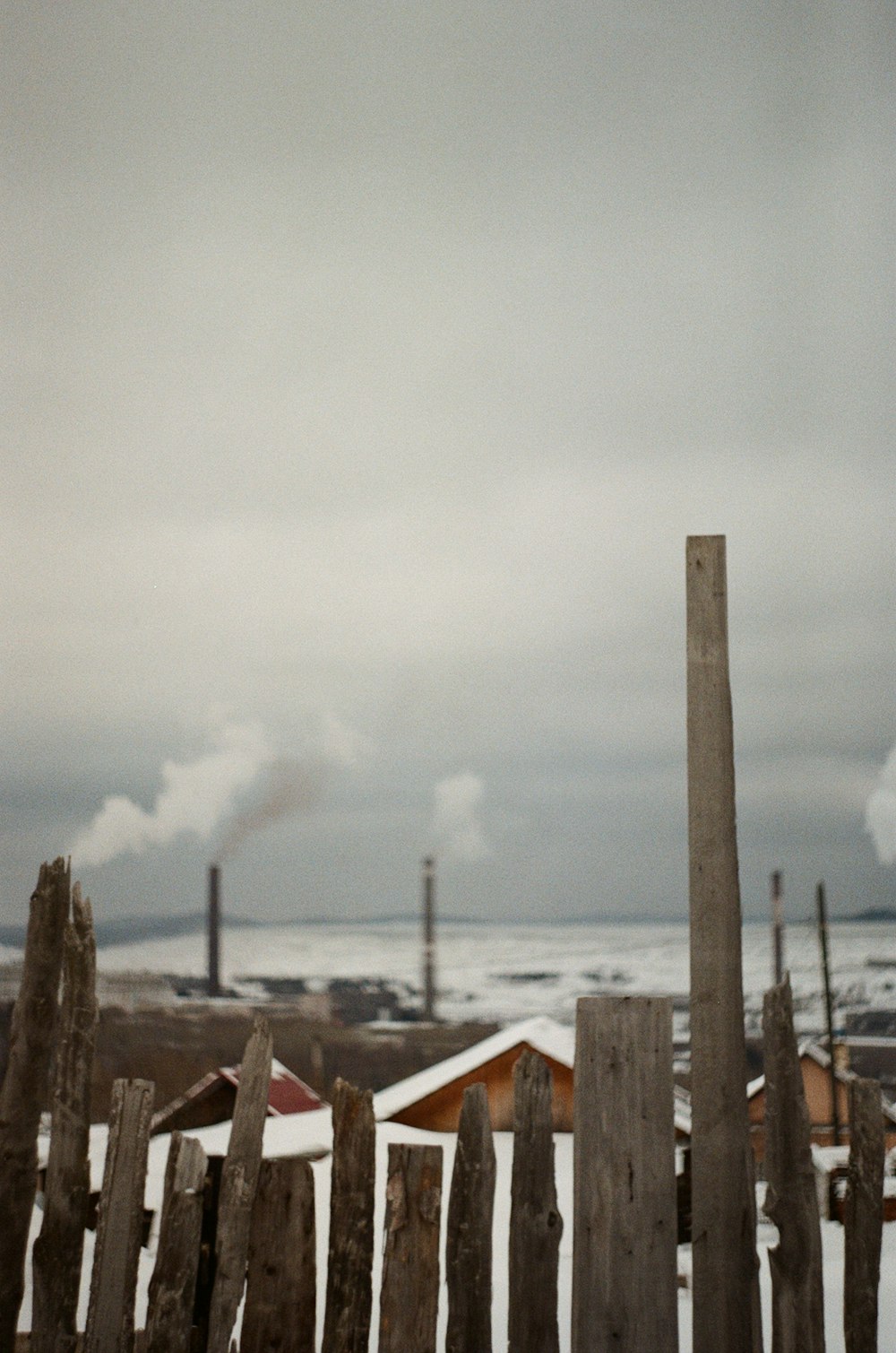 昼間の白い雲�の下の茶色の木造住宅の近くにある茶色の木柵