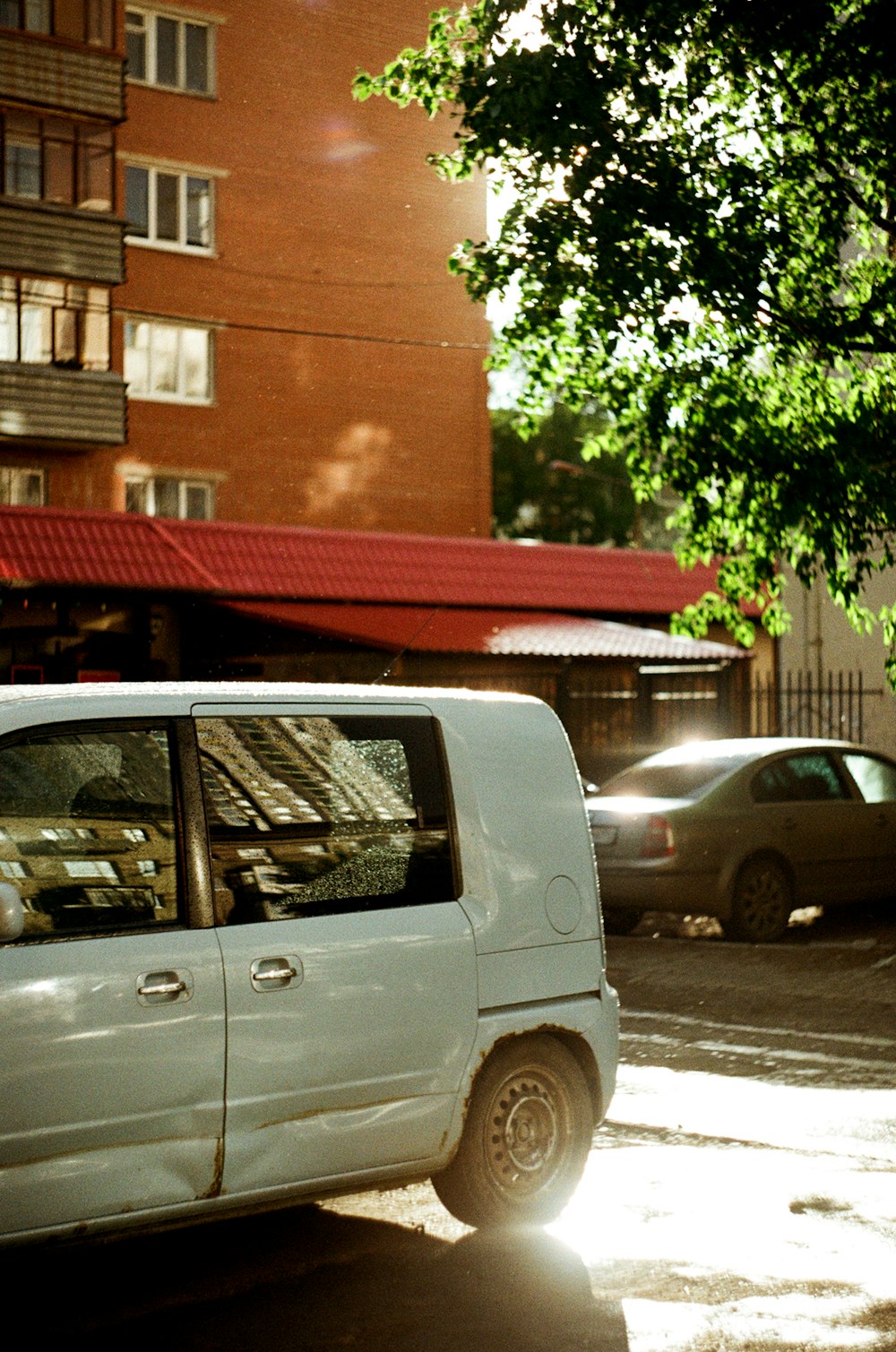 white van parked near brown building during daytime