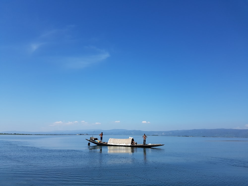 people on boat on sea under blue sky during daytime