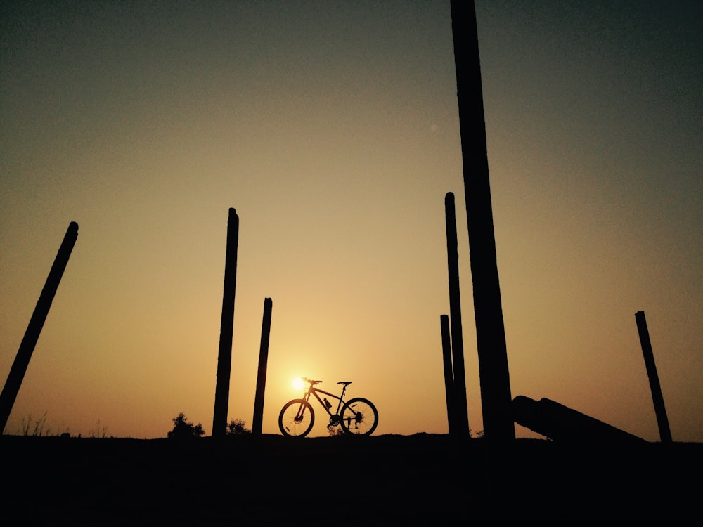 silhouette of a man riding bicycle during sunset