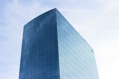 Sleek high-rise commercial building reflecting city skyline on a clear day.