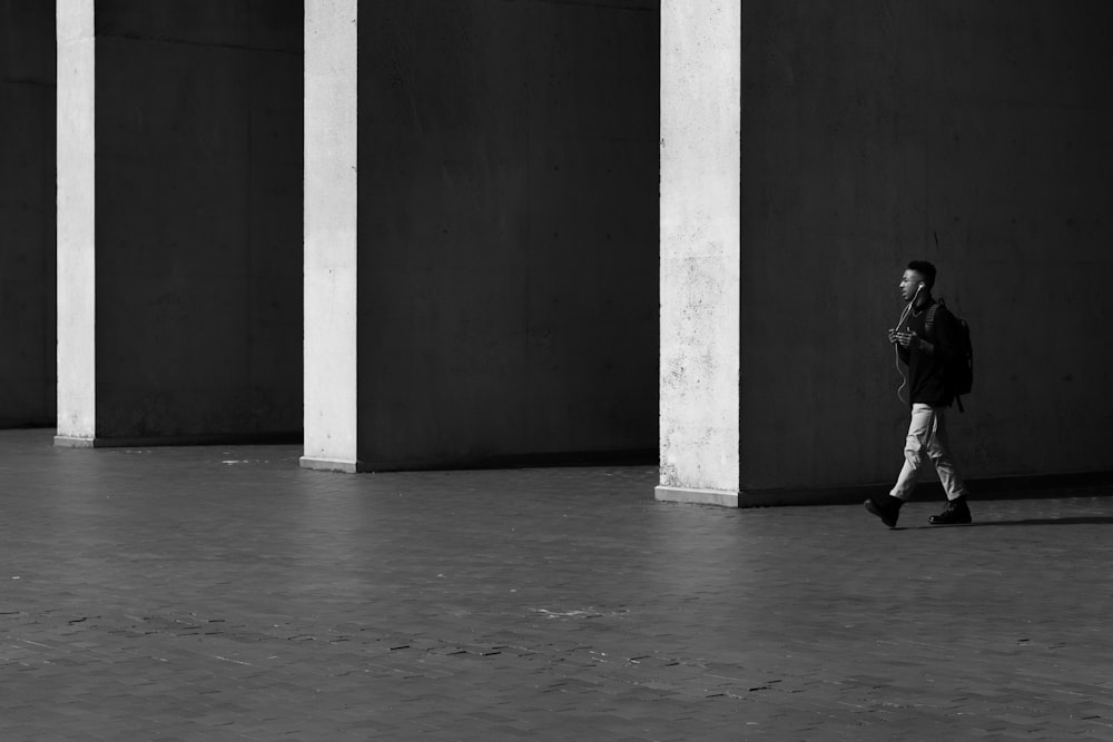 grayscale photo of woman walking on hallway