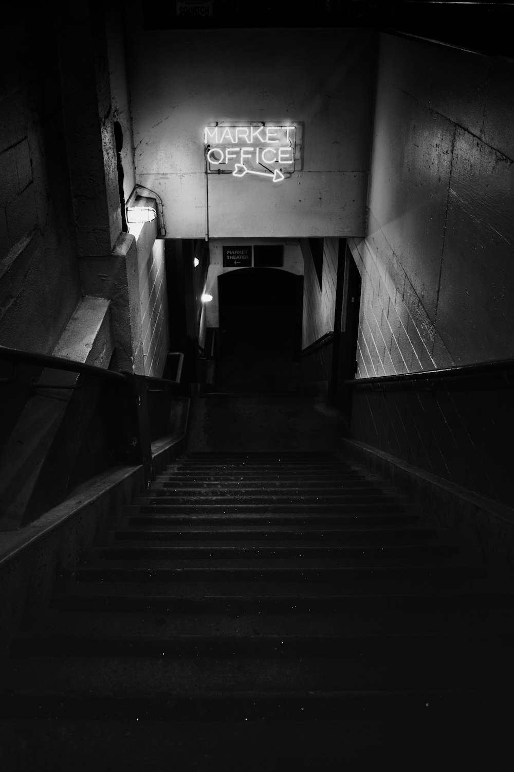 grayscale photo of staircase in tunnel