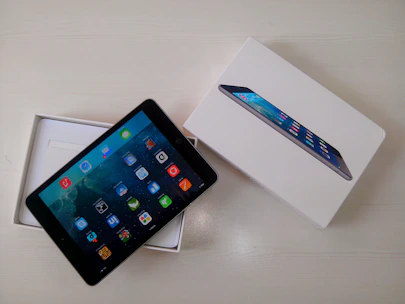 Close-up of a customer happily unboxing a new tablet at home.