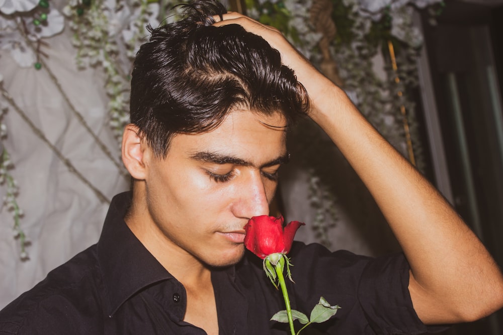 woman in black collared shirt holding red rose