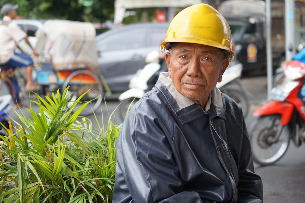 man in black jacket wearing yellow hard hat