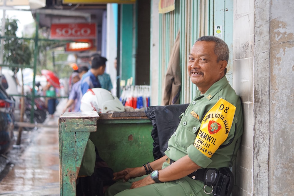 man in green button up shirt sitting on chair