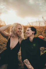 A sunlit candid shot of a couple laughing together in a golden field.
