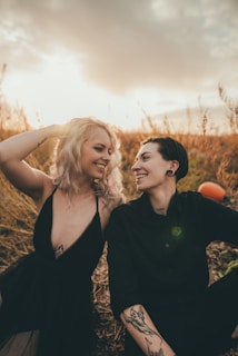 A candid shot of a couple sharing a genuine laugh during a sunset session in a golden field
