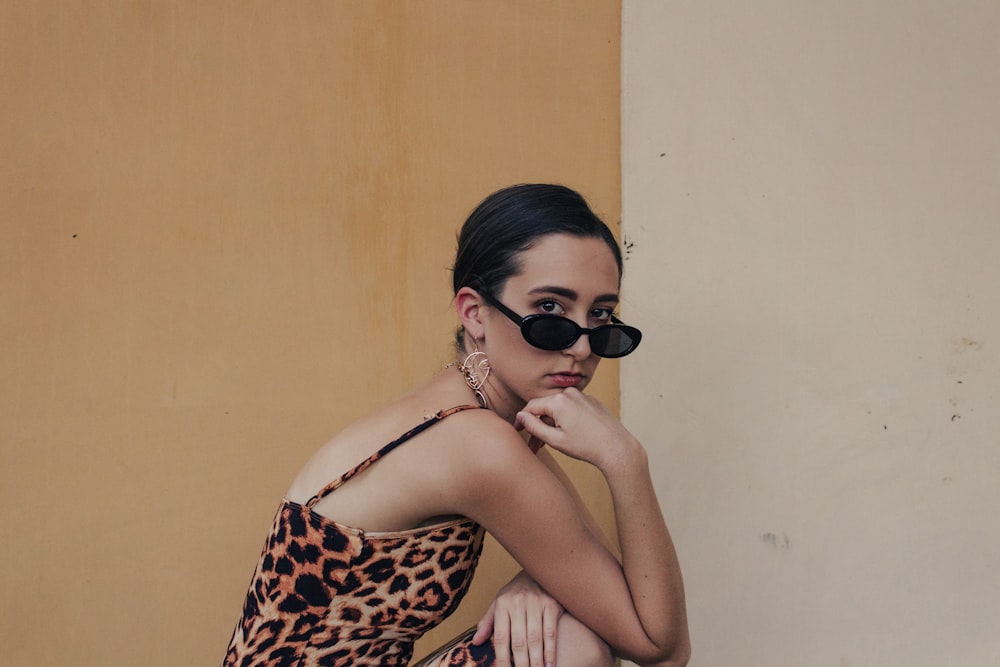 donna in reggiseno leopardato e occhiali da sole neri