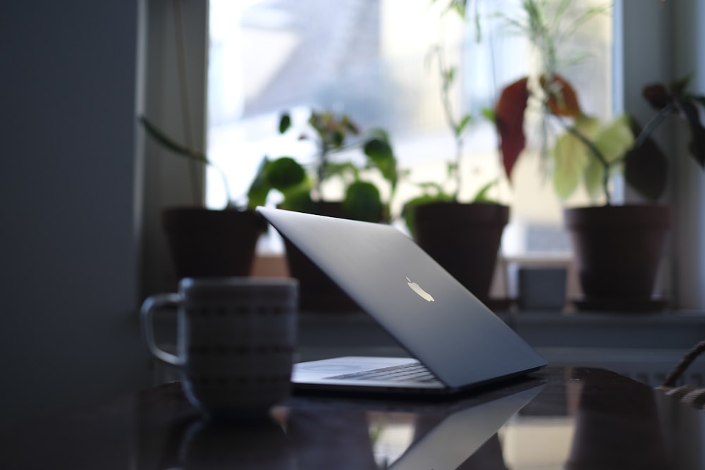 silver macbook on brown wooden table