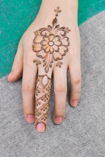 Festive mendhi design with bold geometric shapes and dots decorating a lady's palms