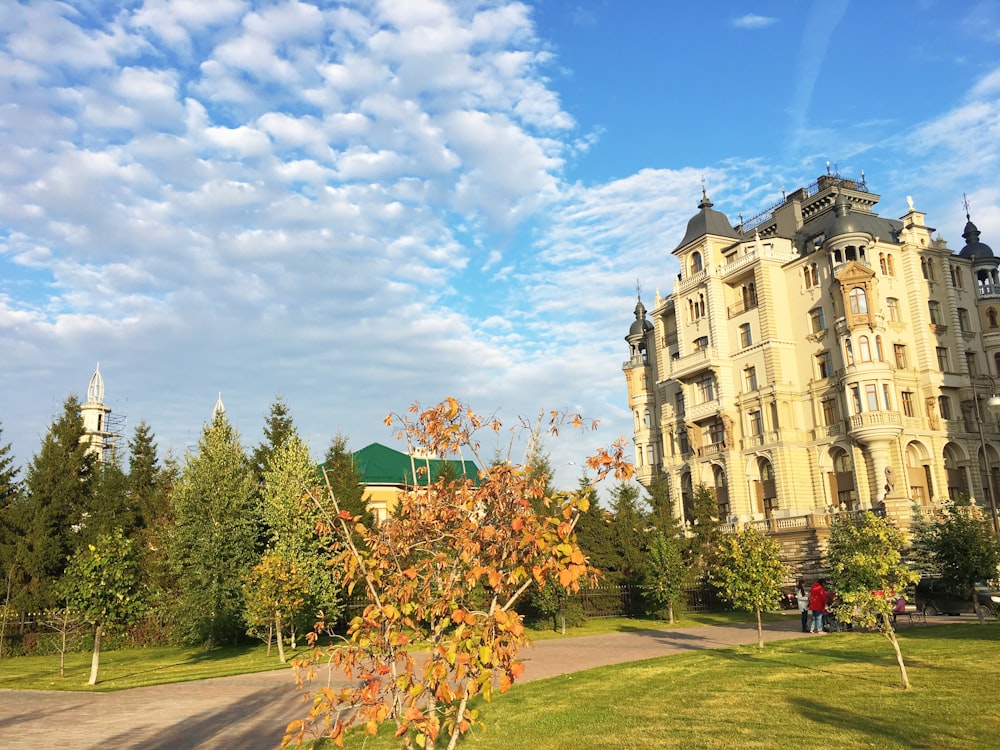 a tall building sitting next to a lush green forest