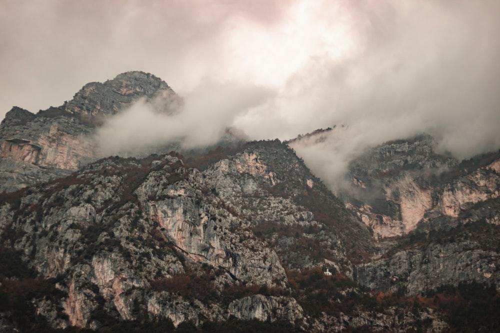 montagne brune et grise sous des nuages blancs