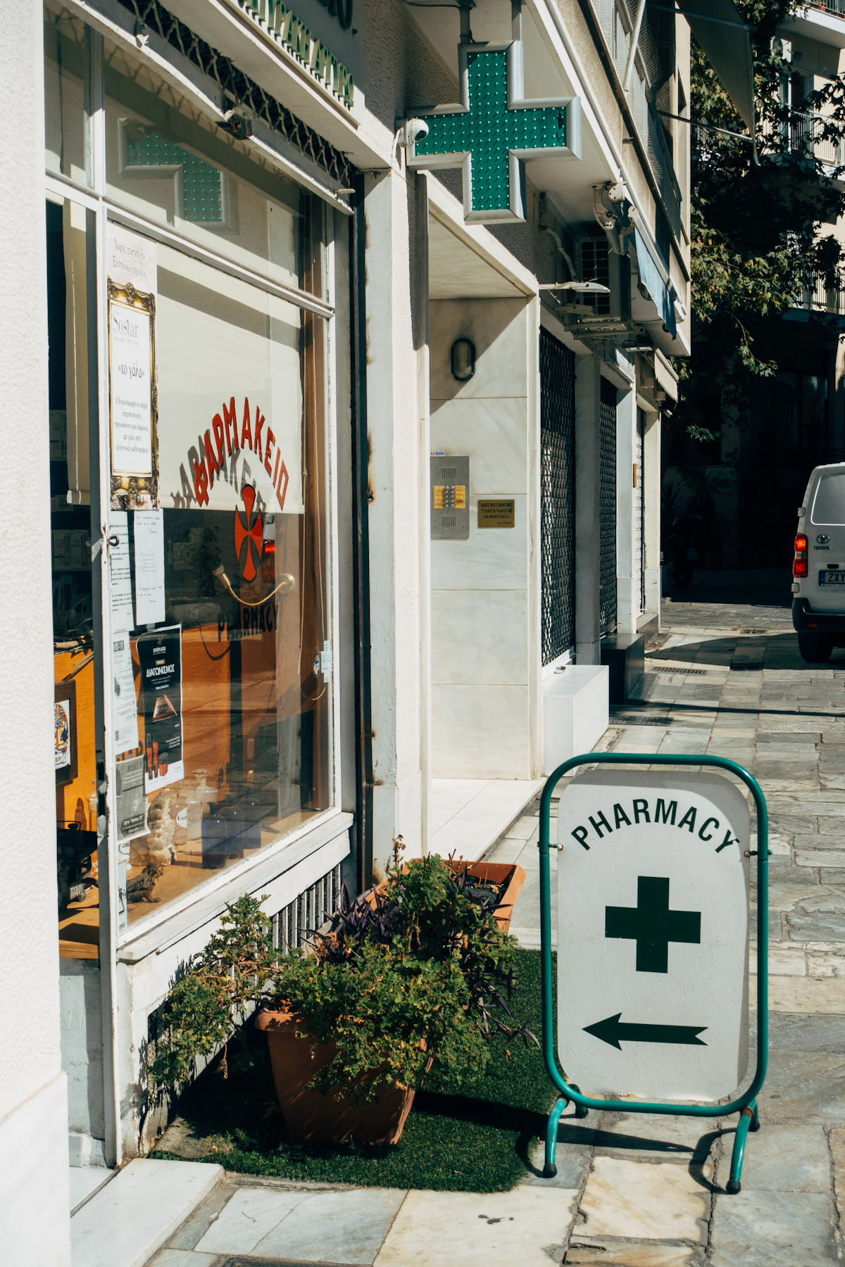 Pharmacy storefront with a green cross sign