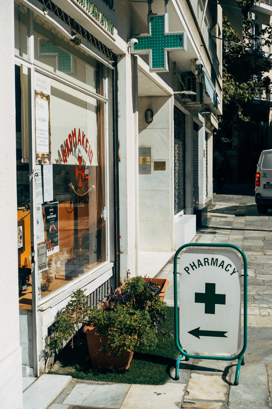 A pharmacy storefront with a green cross