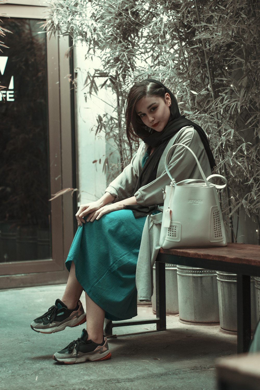 woman in green and white long sleeve dress sitting on brown wooden table