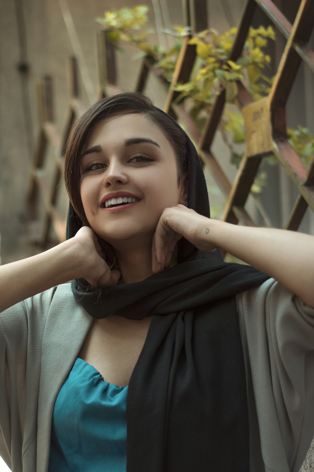 smiling woman in blue shirt and black scarf