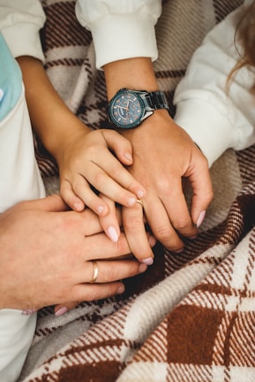 A close-up of intertwined hands resting on a picnic blanket with scattered comic books nearby.