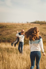 woman in white long sleeve shirt and black pants carrying baby in black and white long