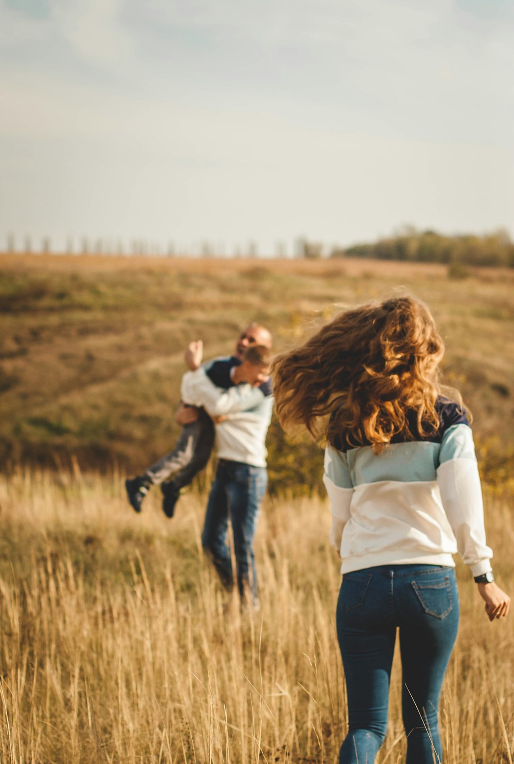 woman in white long sleeve shirt and black pants carrying baby in black and white long