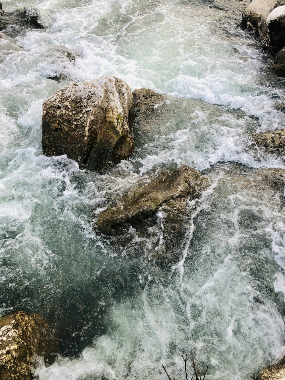 brown rock formation on body of water during daytime