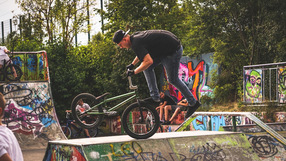 man in black t-shirt riding on black bmx bike