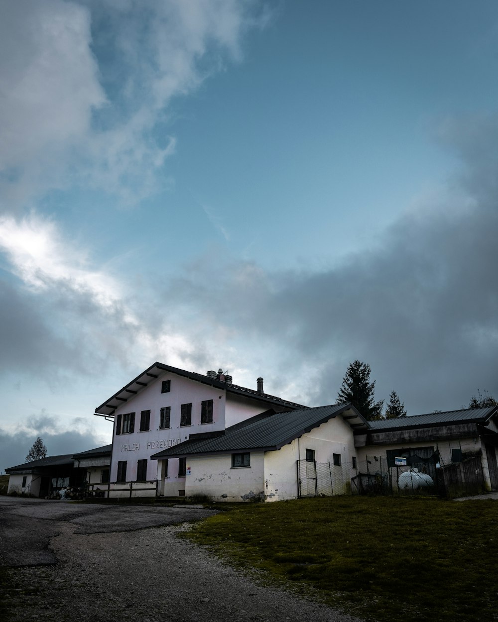 white and black house under white clouds during daytime