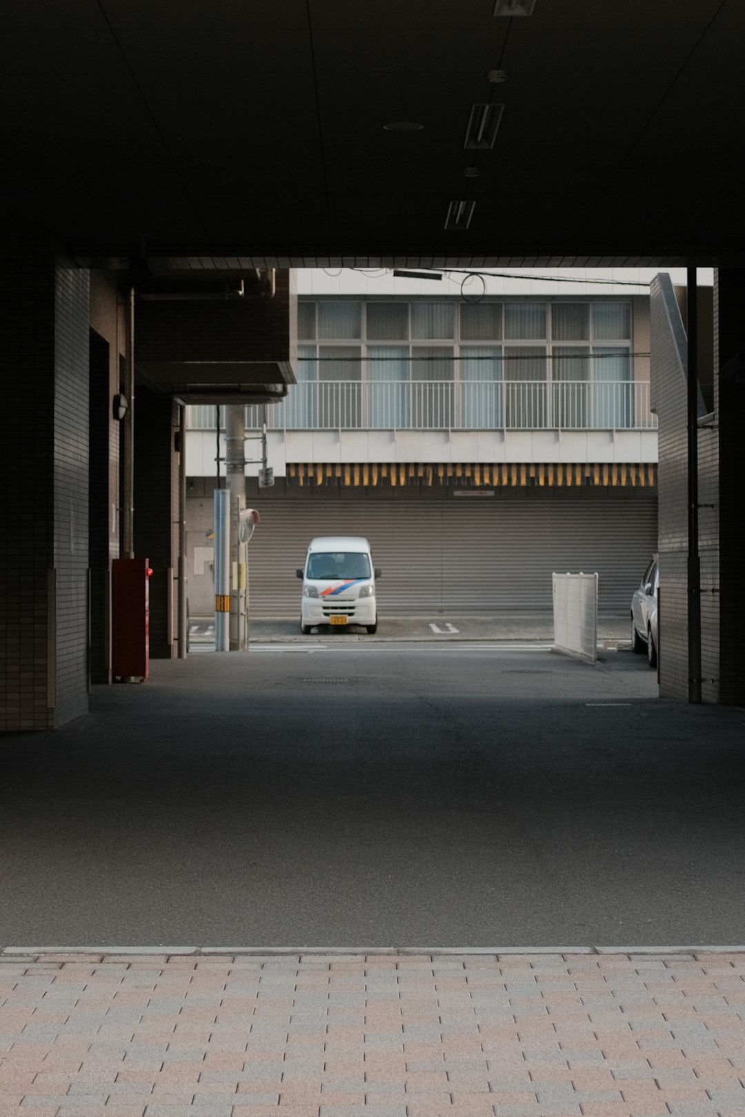 white car parked beside red and white building