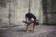 Mr. Anil Kumar Jha demonstrating a yoga posture with gentle guidance to a student.
