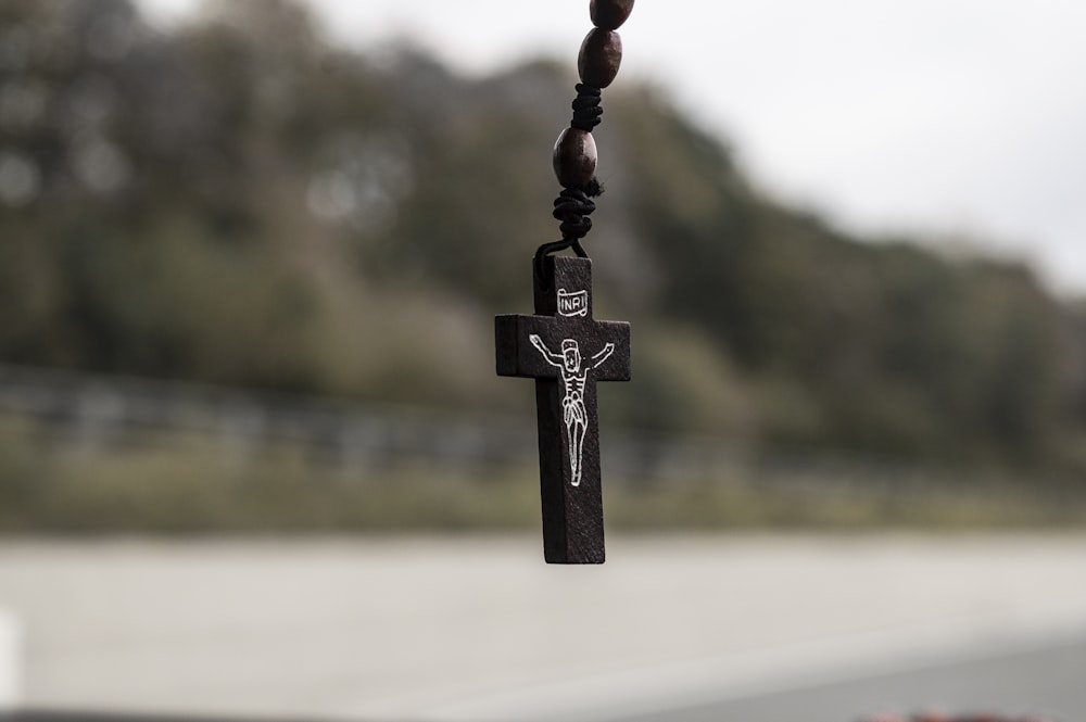 black cross pendant on brown rope