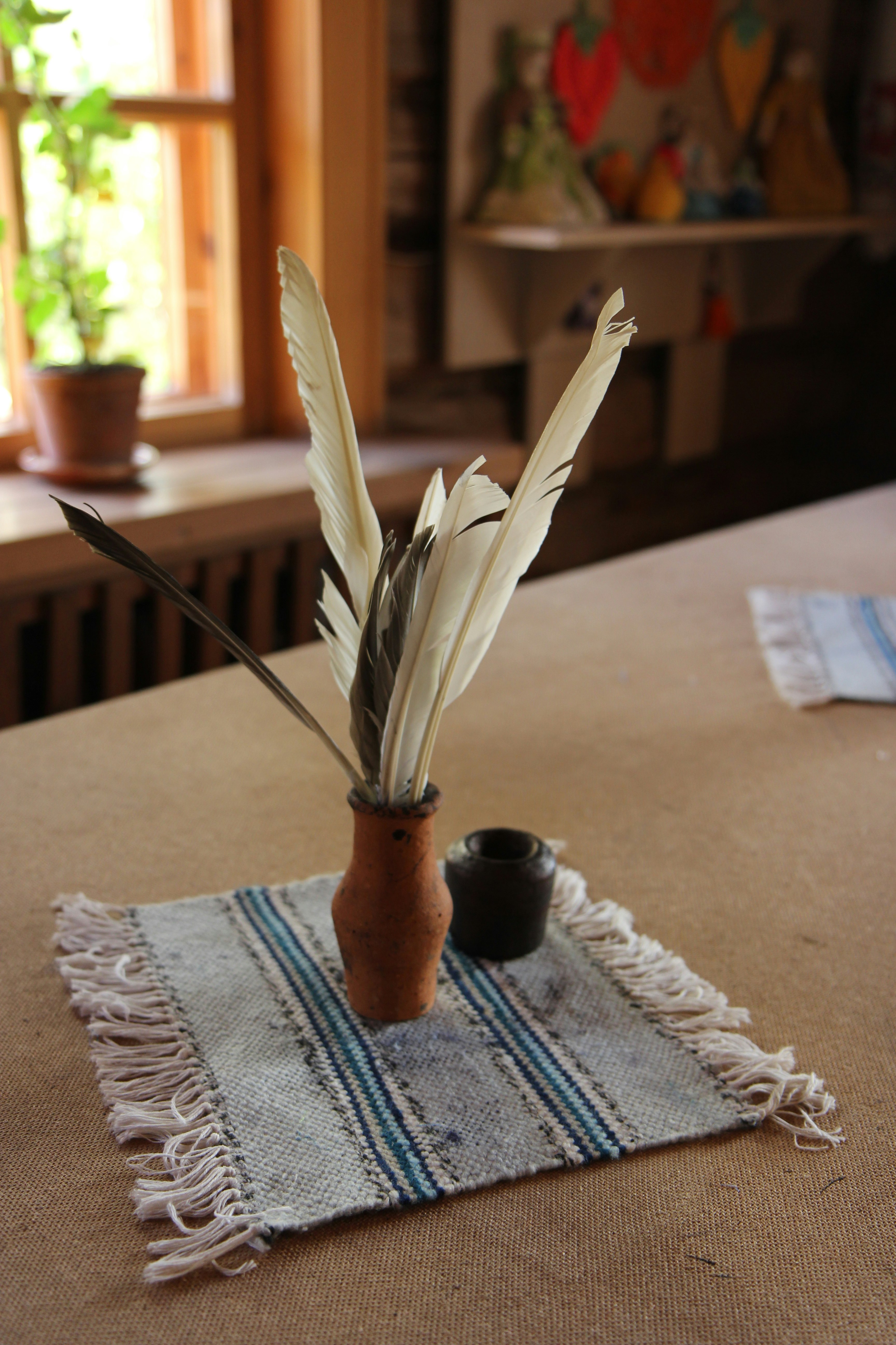 white feather on brown ceramic pot