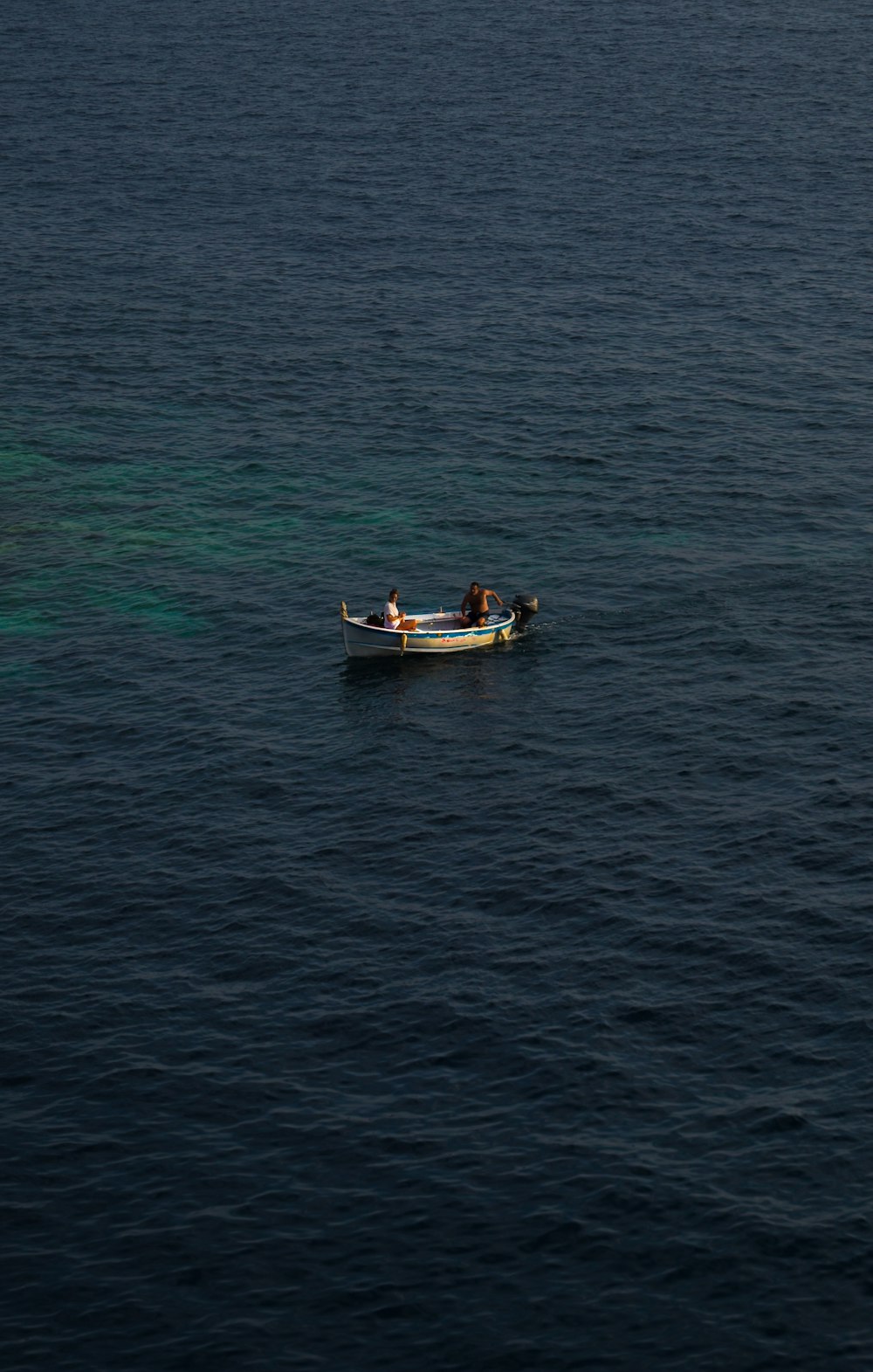 2 people riding on boat on sea during daytime