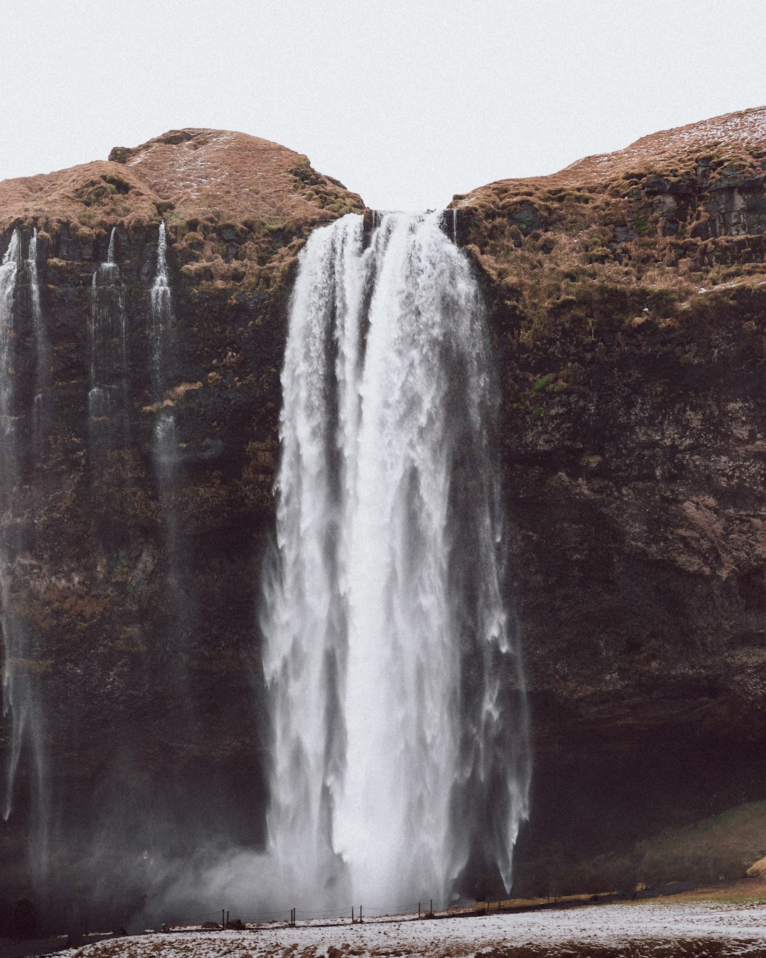 waterfalls on brown rocky mountain during daytime