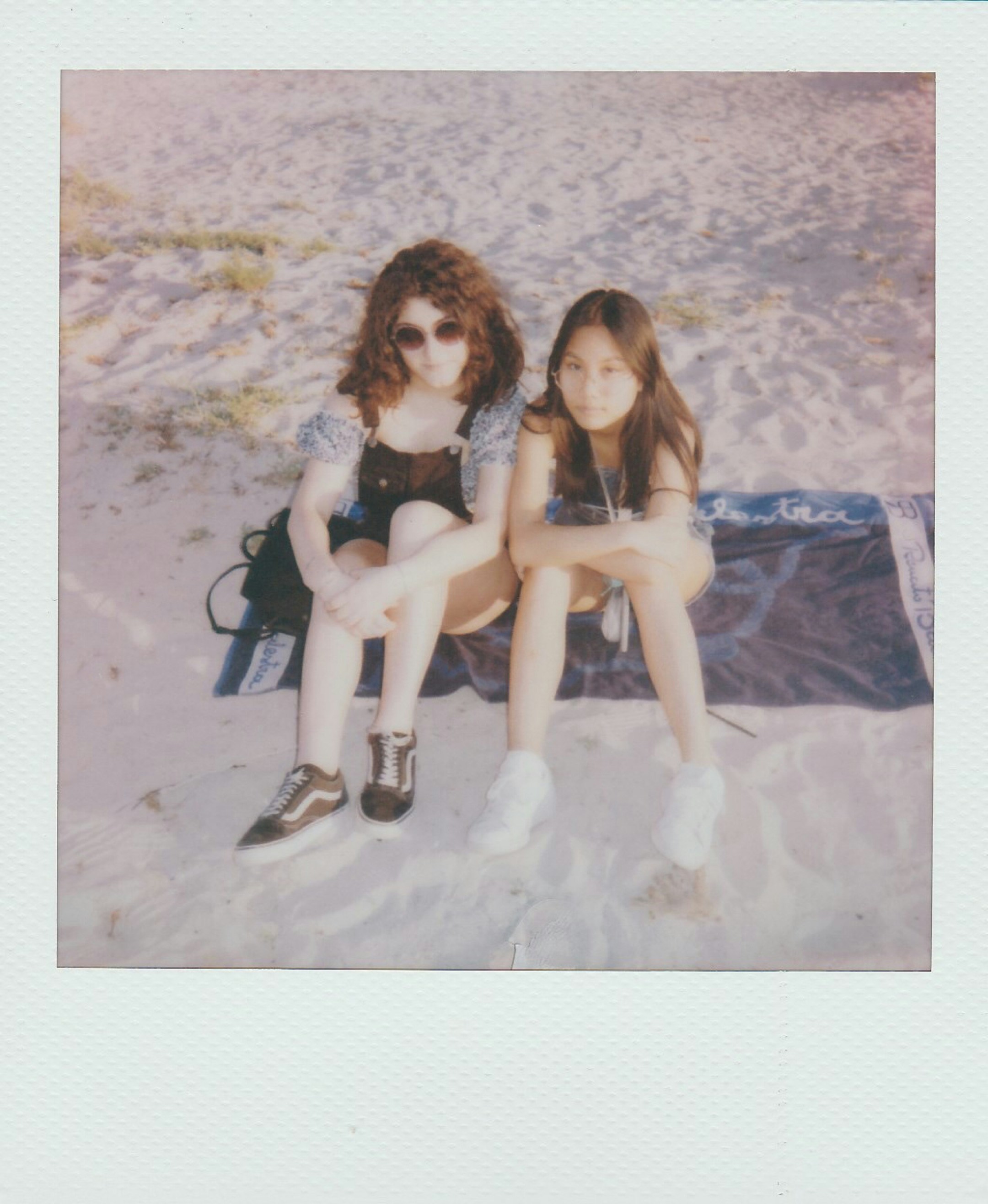 2 women sitting on blue textile