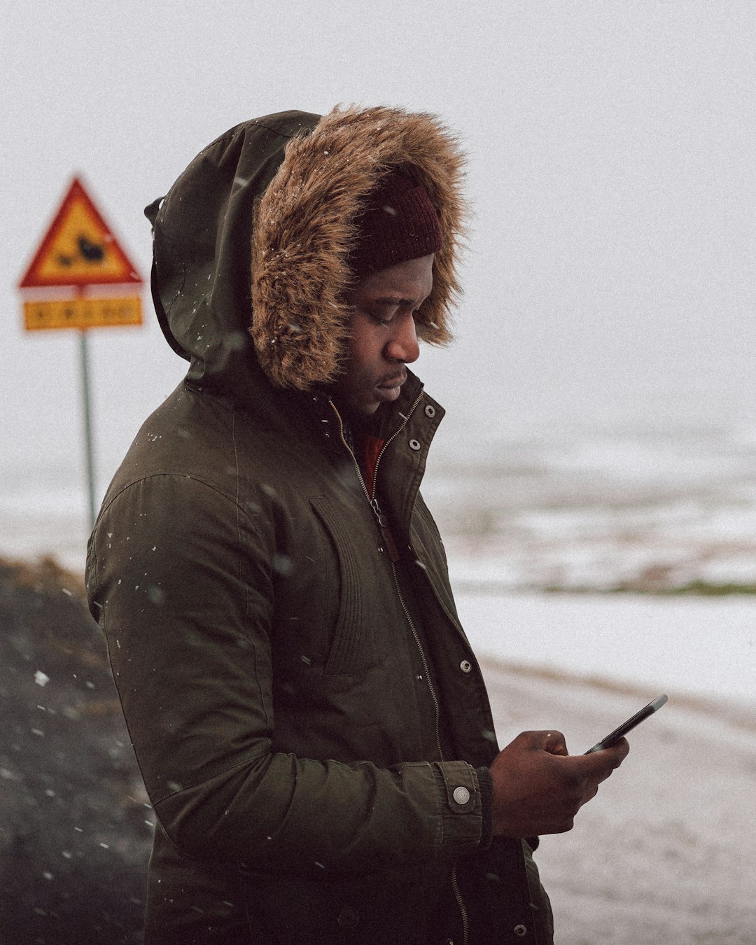 man in black jacket holding smartphone