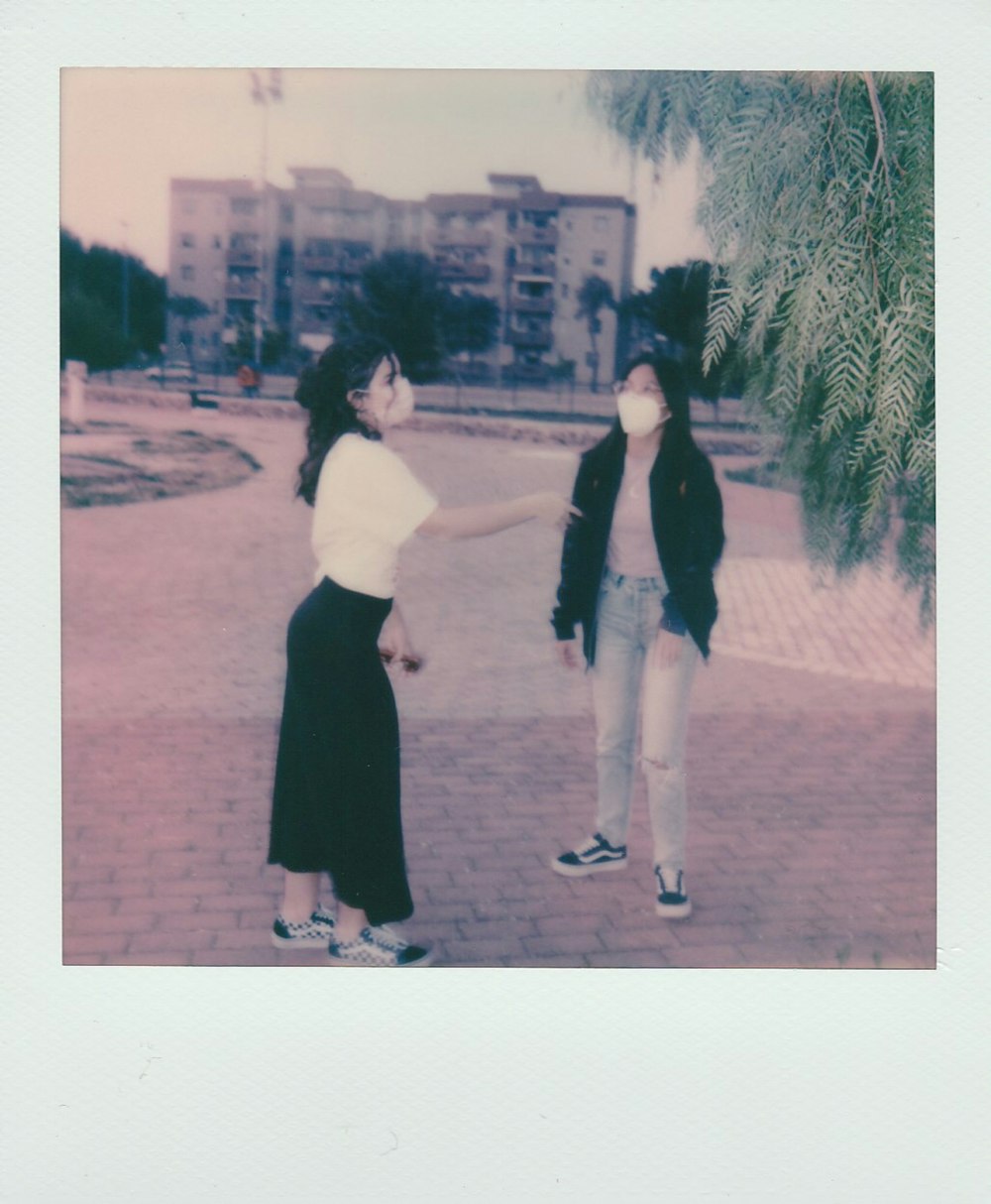 woman in black dress standing beside woman in white dress