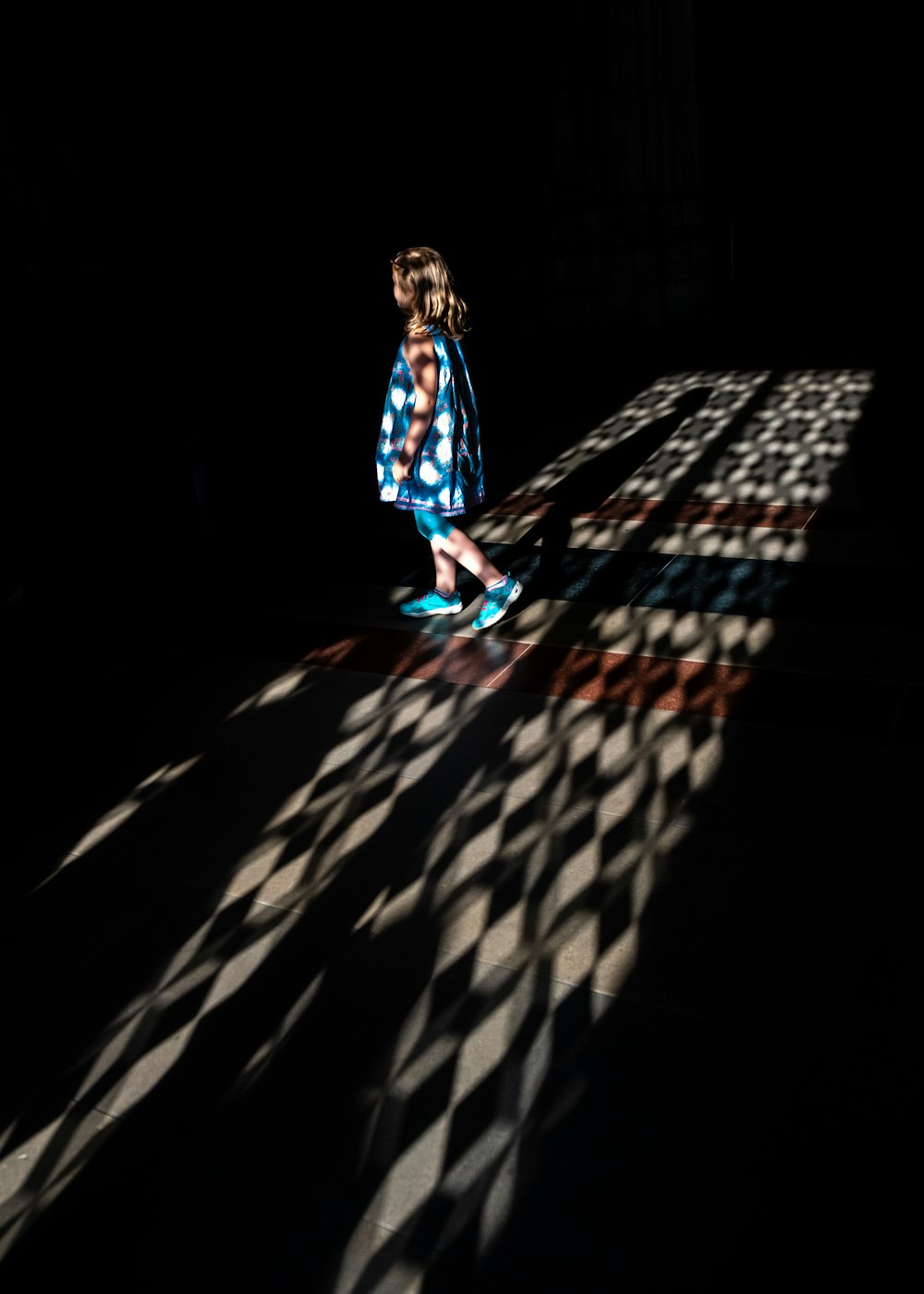 woman in blue and white dress walking on black and white checkered floor
