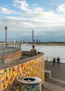 people standing on dock near bridge during daytime