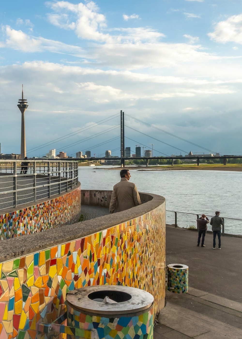 people standing on dock near bridge during daytime