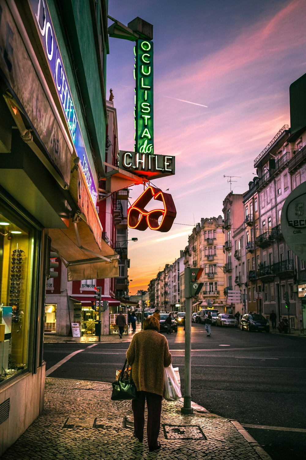 woman in brown coat walking on sidewalk during daytime